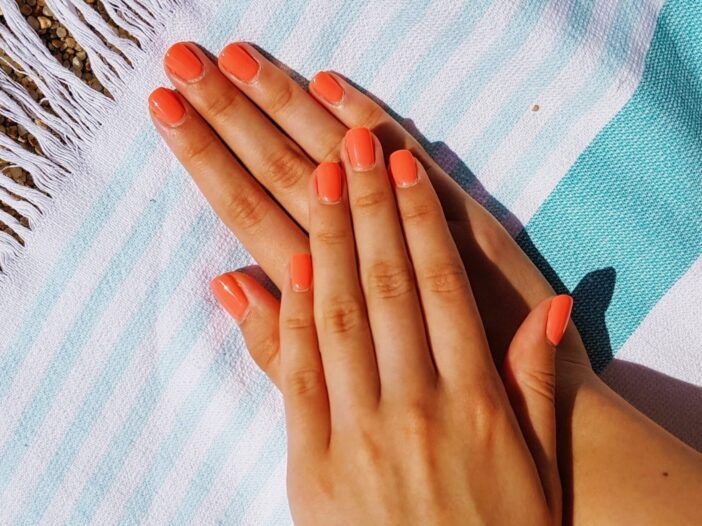 Kuva oranssiksi maalatusta kynnestä rantapeiton päällä.