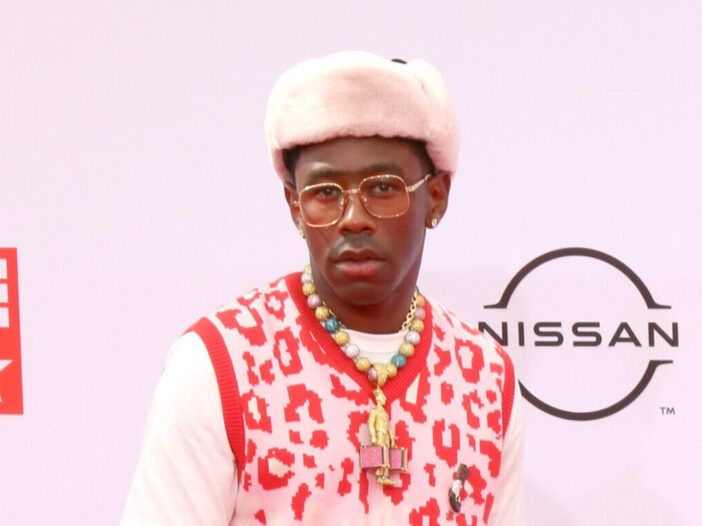 Tyler The Creator vid 2021 BET Awards klädd i en vit, luddig hatt, glasögon och röd och vit tröja med leopardmönstrad