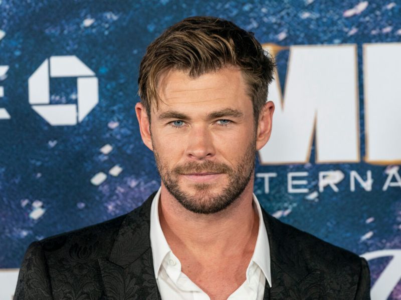 Chris Hemsworth con traje negro y camisa blanca desabotonada