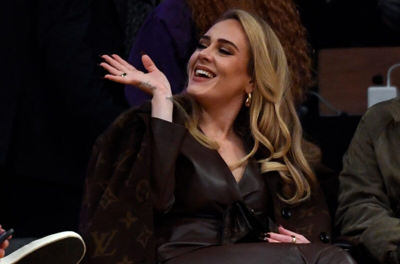 Adele saludando con un abrigo de Louis Vuitton.