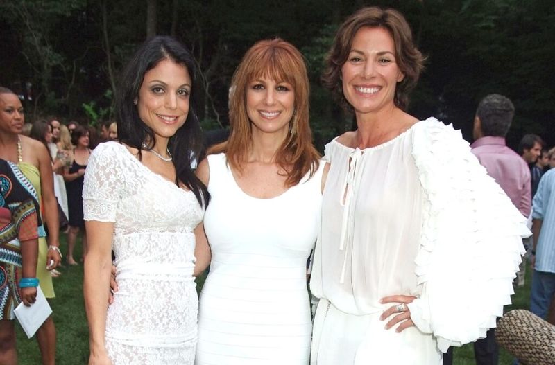 Bethenny Frankel, Jill Zarin ja Luann De Leseppes kannavad valgeid kleite ja naeratavad.