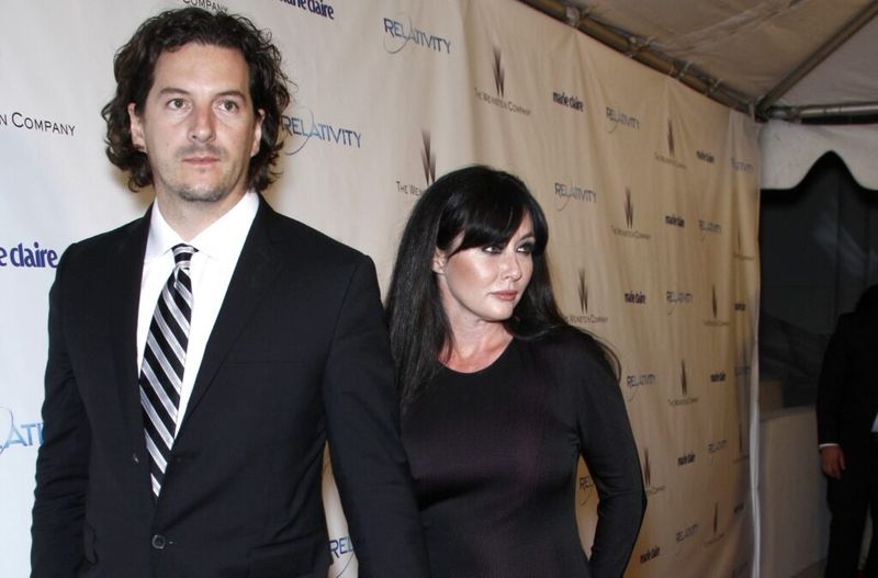 Shannen Doherty i en svart klänning går med sin man Kurt Iswarienko i en svart kostym.