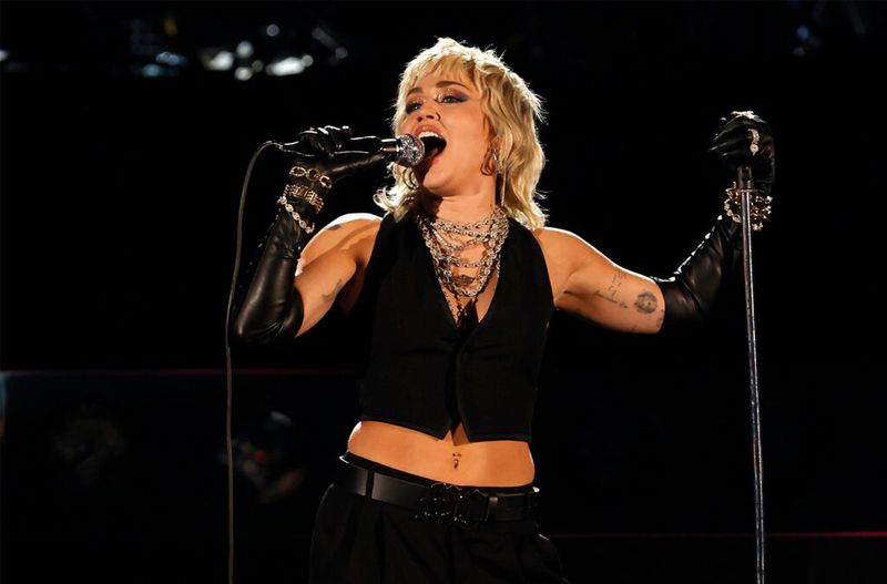 Miley Cyrus esinemas laval mustas äralõigatud särgis ja mustades pükstes.