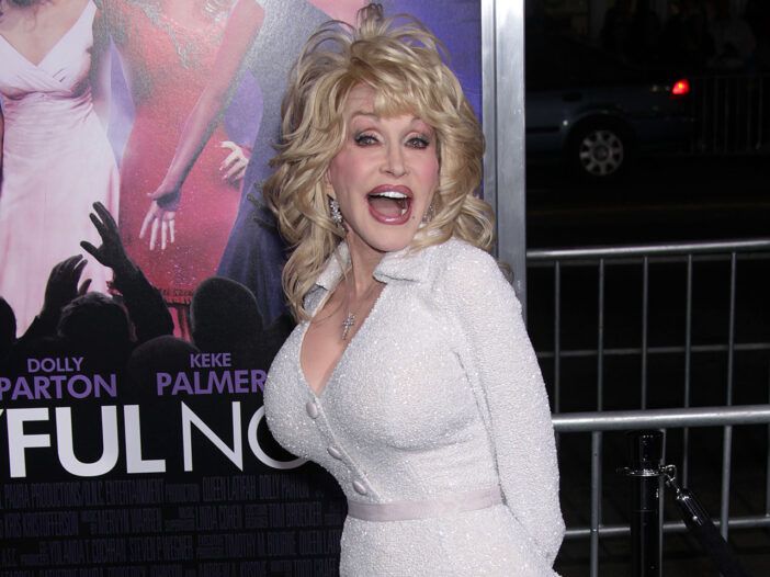 Dolly Parton i helt hvitt, med munnen agape