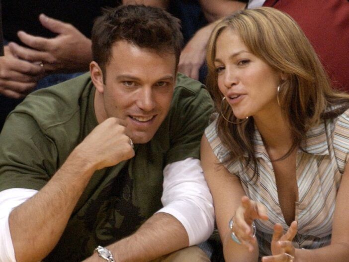Ben Affleck och Jennifer Lopez lutar sig intill varandra under en basketmatch