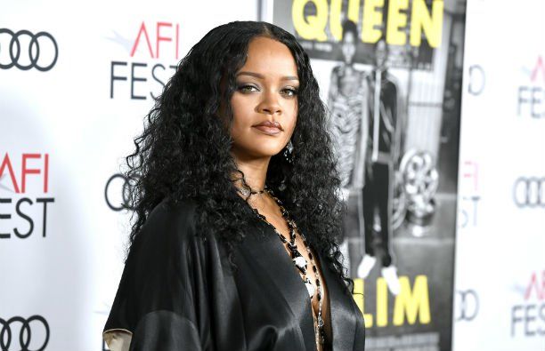 Rihanna melnā, zīdainā ietīšanas kleitā uz sarkanā paklāja.