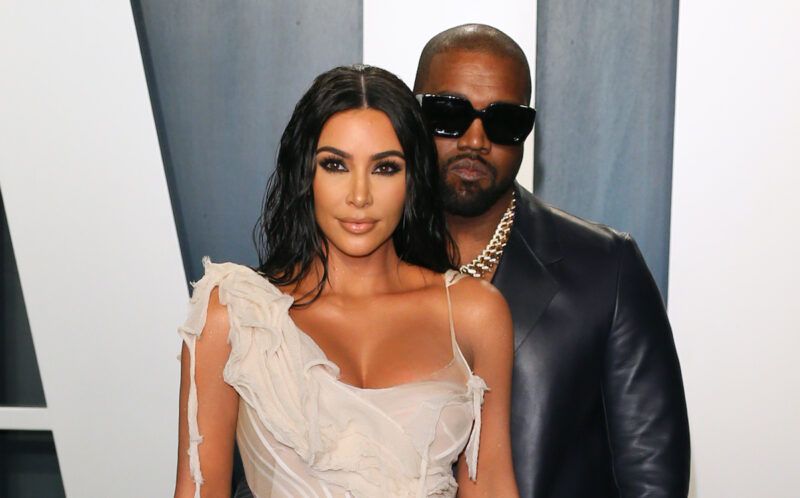 Kim Kardashian balta suknele su Kanye Westu odiniu švarku už nugaros