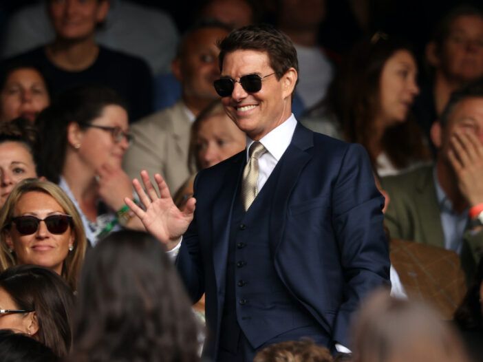 Tom Cruise con traje sonriendo entre la multitud