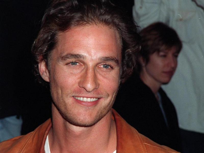 Matthew McConaughey ler mot kameran i en brun skinnjacka