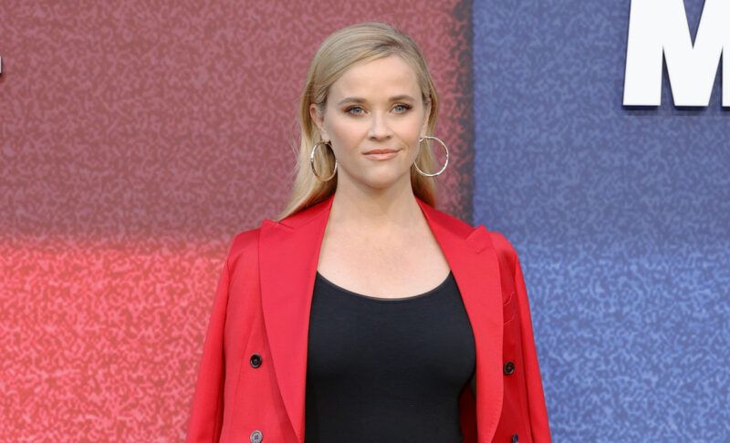 Reese Witherspoon con un top nero e una giacca rossa
