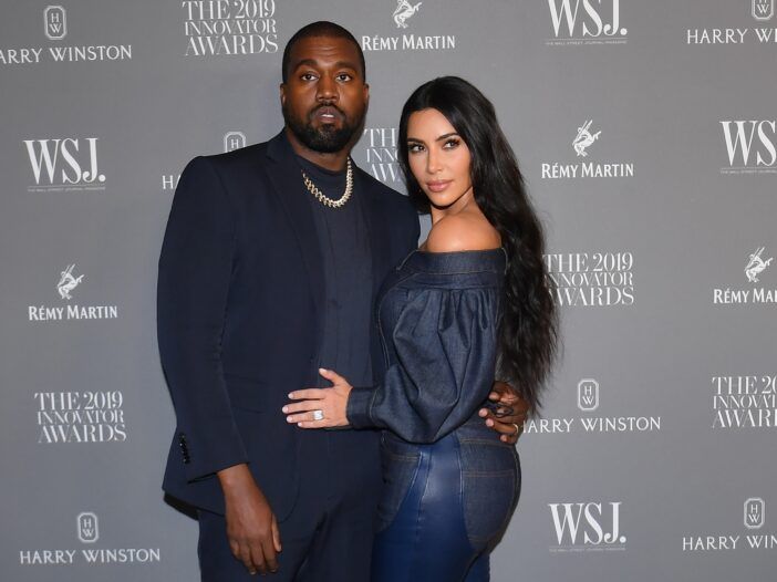 Kanye West ja Kim Kardashian seisovat yhdessä punaisen maton tapahtumassa.