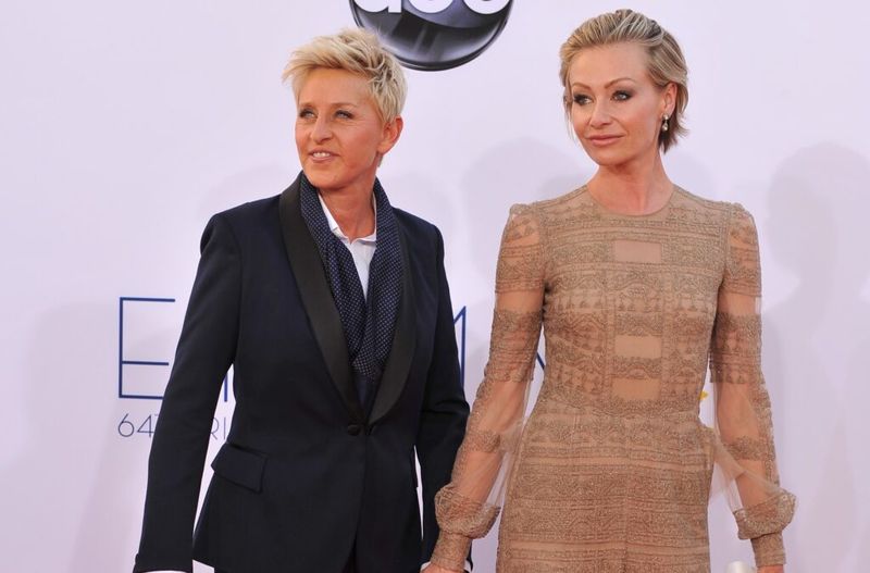 Ellen DeGeneres kannab musta ülikonda ja seisab koos Portia de Rossiga beežis kleidis punasel vaibal