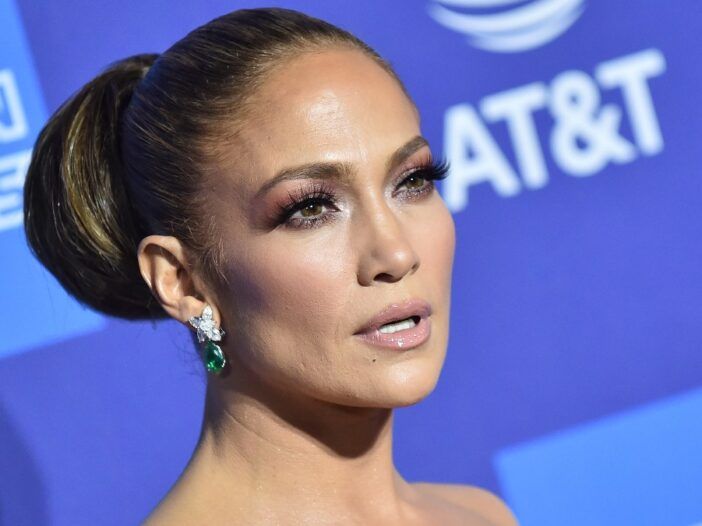 Jennifer Lopez luce un vestido strapless sobre un fondo azul