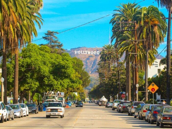 Las colinas de Hollywood y el famoso letrero de Hollywood se ciernen sobre una calle de Los Ángeles