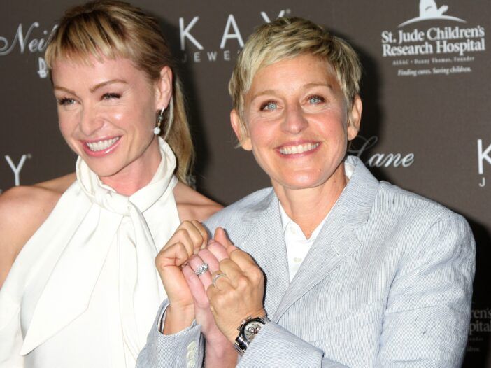 Portia de Rossi în stânga, Ellen DeGeneres în dreapta, ținând împreună verighetele.