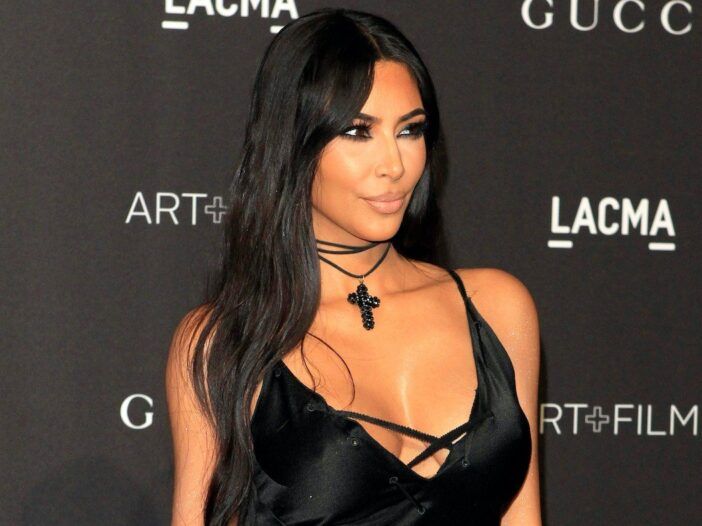 Kim Kardashian sorridente con un abito nero allacciato