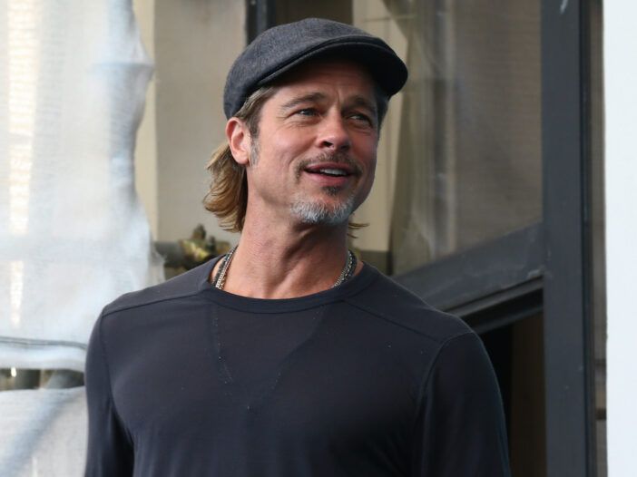 Brad Pitt sorride con una maglietta grigia