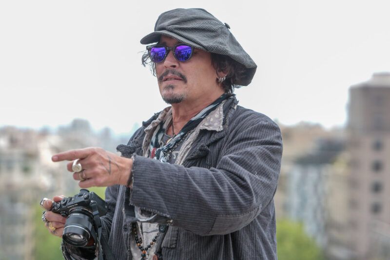 Johnny Depp vonku v sivom kabáte a klobúku