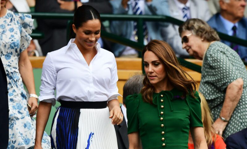 Meghan Markle i en hvit bluse med Kate Middleton i en grønn kjole