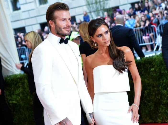 David Beckham purtând un frac alb în picioare cu Victoria Beckham, care