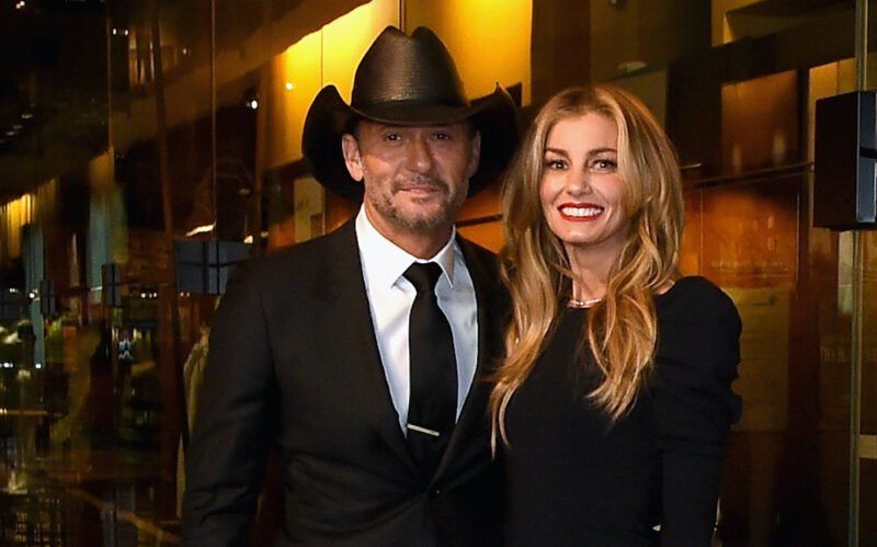 Tim McGraw sa usmieva v obleku a kovbojskom klobúku s Faith Hill v čiernych šatách