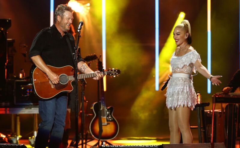 Gwen Stefani con un vestido blanco en el escenario con Blake Shelton