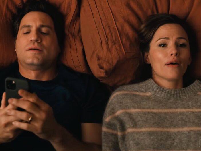 Snímka obrazovky z Yes Day s Edgarom Ramirezom a Jennifer Garner ležiacimi na posteli.