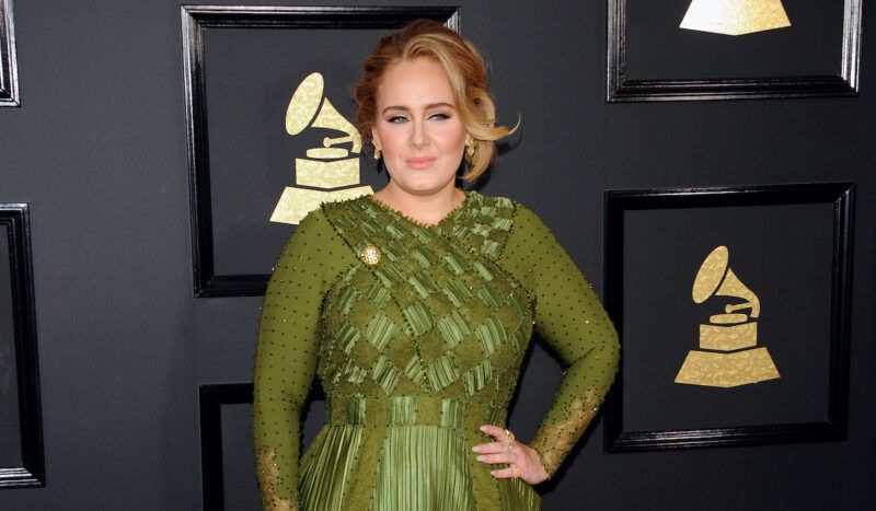 Adele ar roku uz gurniem zaļā kleitā 2017. gadā