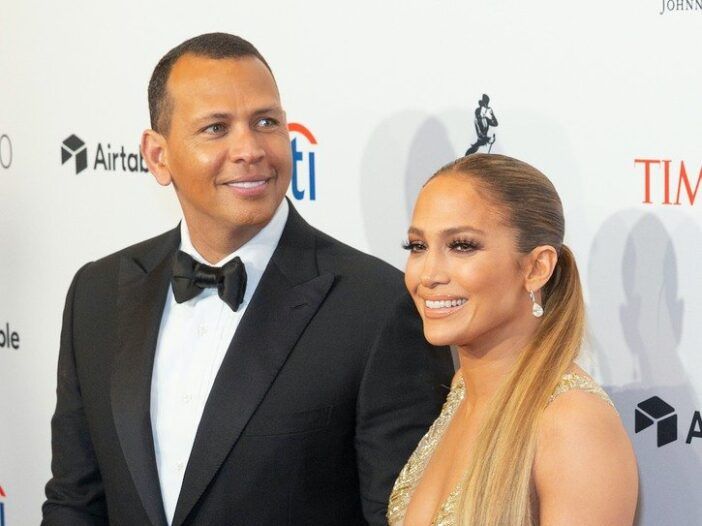 Alexas Rodriguezas šypsosi vilkėdamas smokingą su Jennifer Lopez auksine suknele