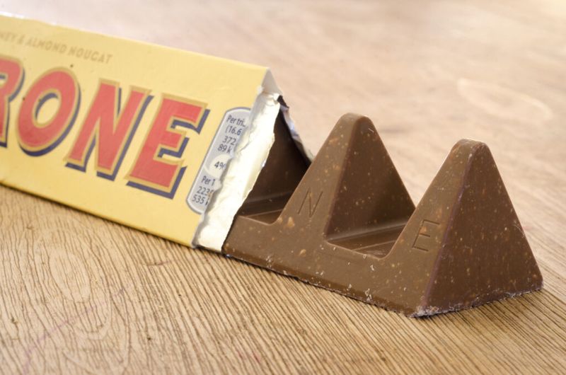 Toblerone šokolado plytelės, iš dalies ištrauktos iš įvyniojimo, vaizdas iš arti.