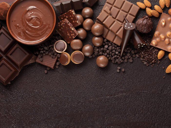 Olika typer av choklad på en brun bakgrund.