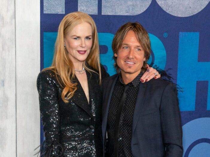 Nicole Kidman och Keith Urban, båda klädda i svart, står framför en blå bakgrund