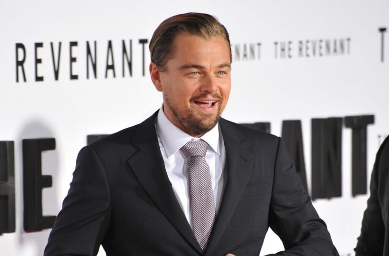 Musta ülikonda kandev Leonardo DiCaprio naeratab Revenanti esilinastusel laialt
