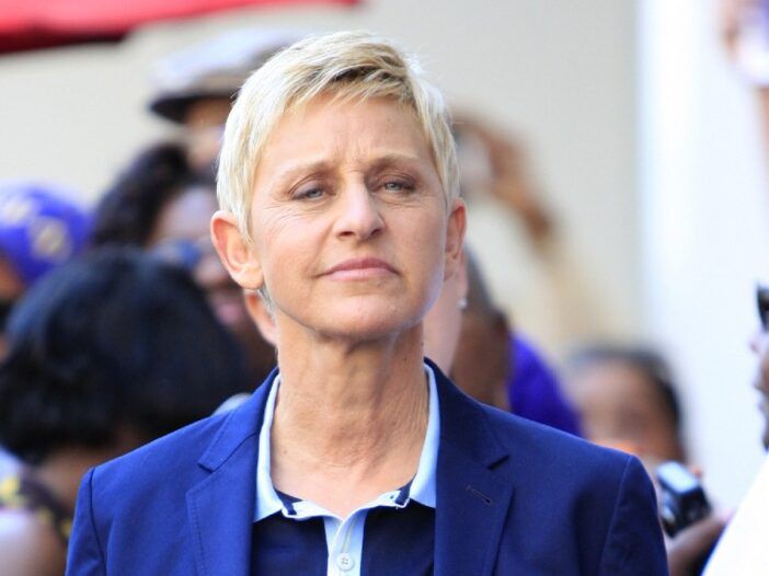Ellen DeGeneres na javnem dogodku nosi modro obleko in temno majico