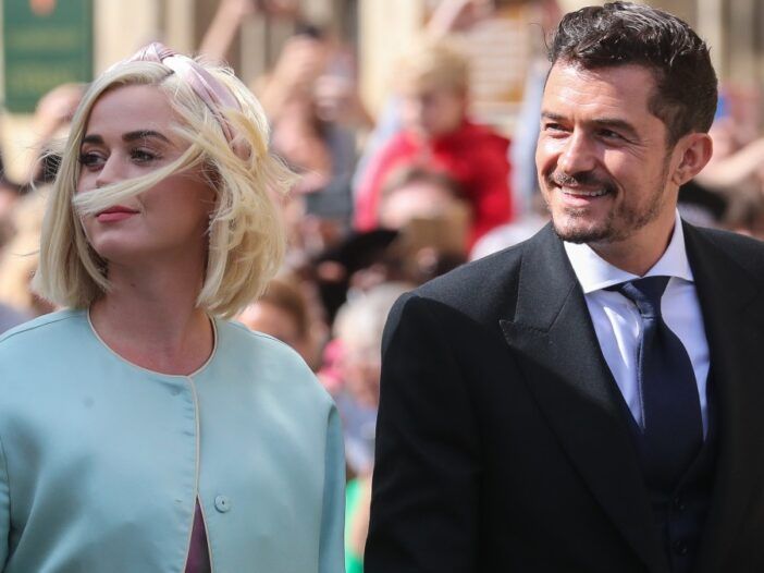 Katy Perry bär en ljusblå jacka när hon går med Orlando Bloom, i mörk kostym