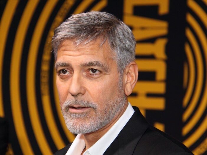 nærbilde av George Clooney i dress som ser frem mot en gul bakgrunn