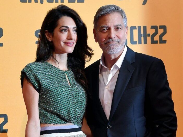 Rohelises topis naeratav Amal Clooney ja ülikonnas abikaasa George Clooney.