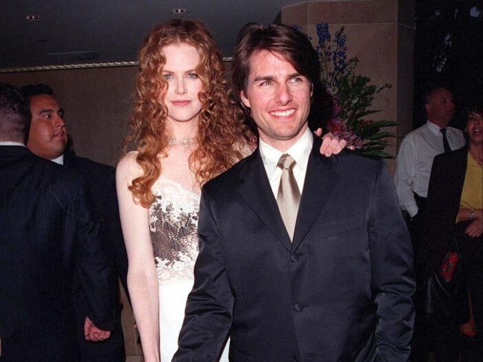 Nicole Kidman bär en vit klänning och står med Tom Cruise, iklädd mörk kostym