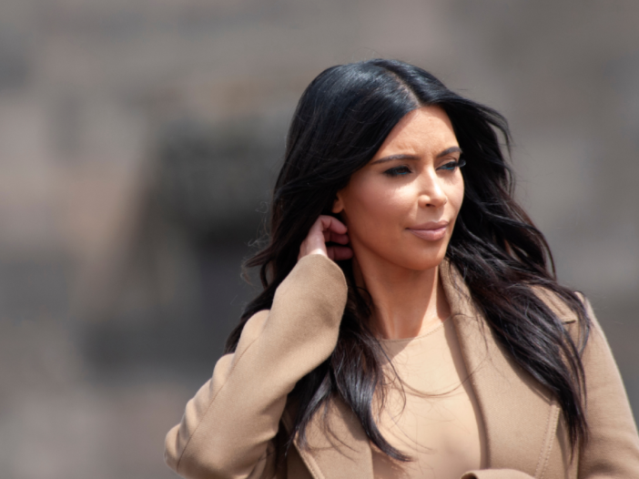 Kim Kardashian har på seg en beige jakke og topp når hun går offentlig
