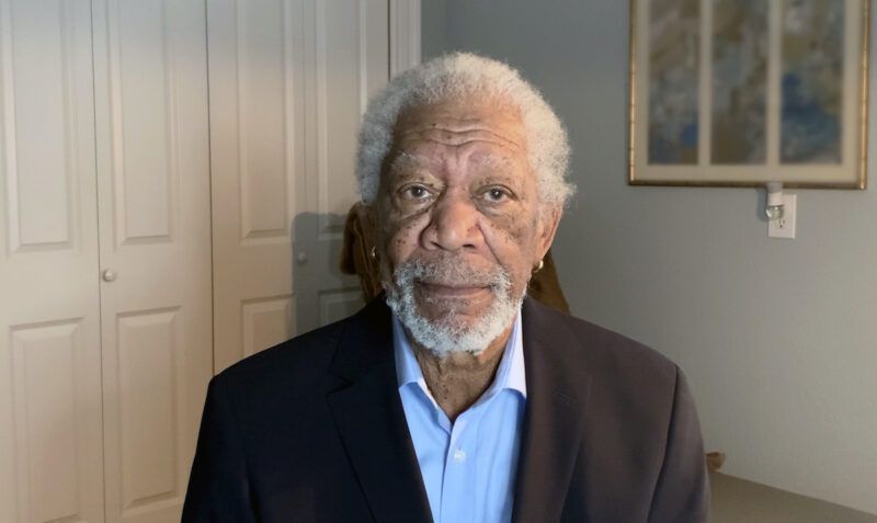 Morgan Freeman într-o cămașă albastră și jachetă neagră