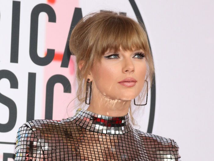 Taylor Swift con un vestido plateado reflectante