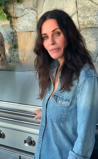 Screengrab av Courteney Cox ved siden av en grill fra videoen hennes på sosiale medier som lager kalkunburgere.