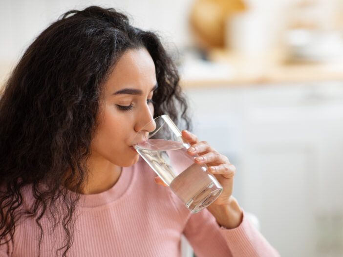 Imagen de mujer bebiendo agua.