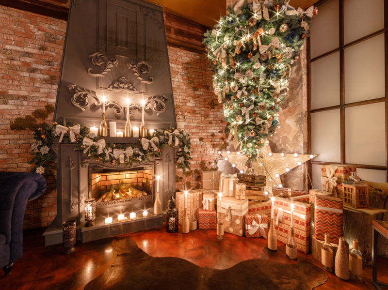 Una chimenea decorada y un árbol de navidad al revés rodeado de luces parpadeantes
