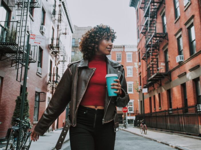 Imaginea unei femei care se plimbă prin New York.