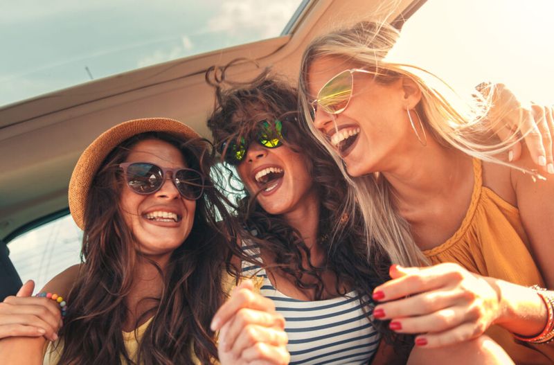 Tres mujeres riéndose en un viaje por carretera