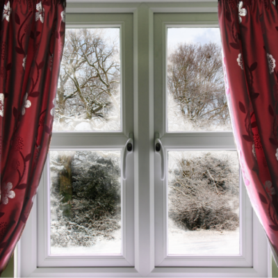 Vista de invierno desde una ventana a través de una cortina roja