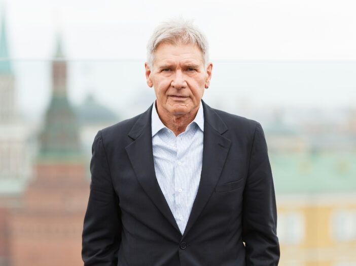 Harrison Ford iført en svart dress uten slips under en fotosamtale