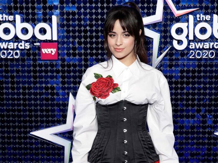 Camila Cabello i en hvit og svart kjole med en stor rose brodert på