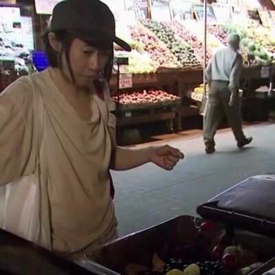केट हाशिमोटो, एक सफेद टॉप पहने हुए, न्यूयॉर्क शहर में ताजे फलों के कचरे के डिब्बे के माध्यम से खोदता है